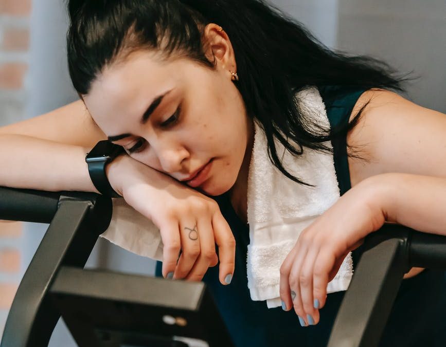 exhausted young woman on exercise machine